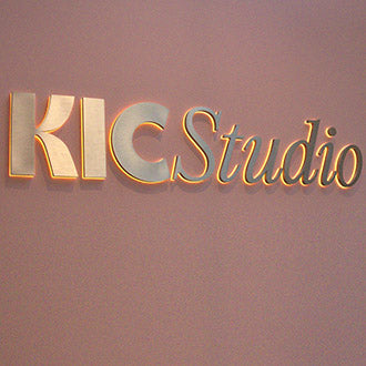 Backlit halo sign with warm light spilling onto the wall